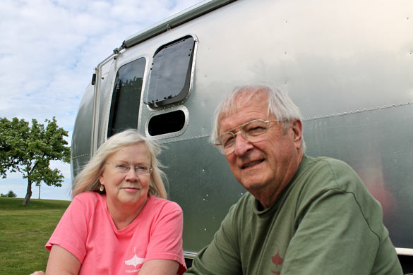 Tom and his wife, Sandi, sitting in front of their Airstream