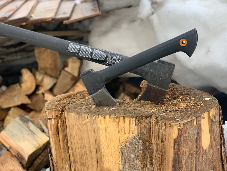 an ax and a hatchet, both by fiskers, stuck into a rounder of wood