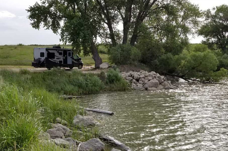 an RV camping for free along a river in Kansas