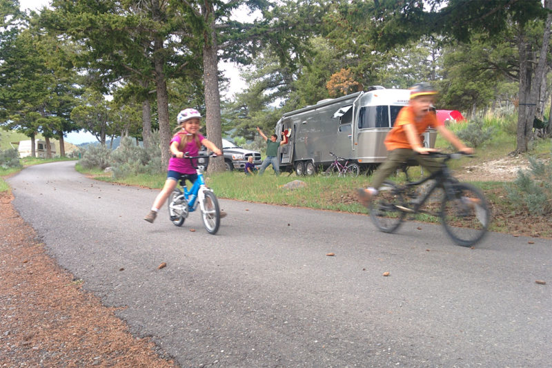 Kids on bikes by an Airstream trailer