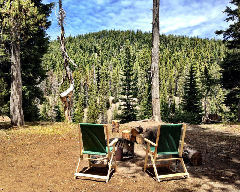 two camp chairs facing a forest