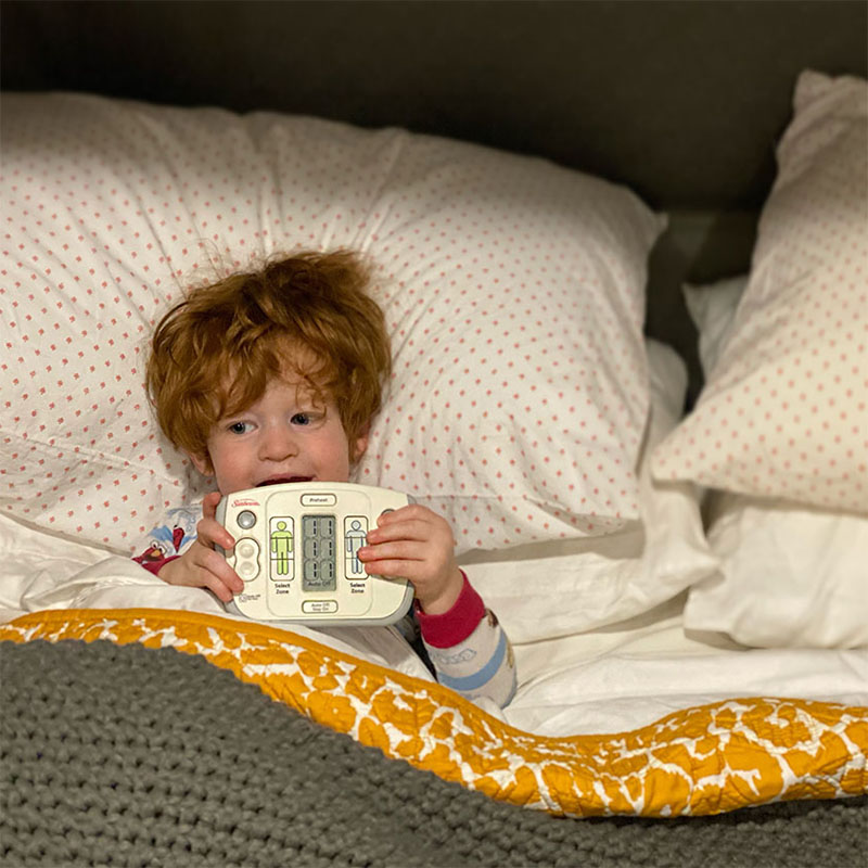toddler in bed with a bed heater