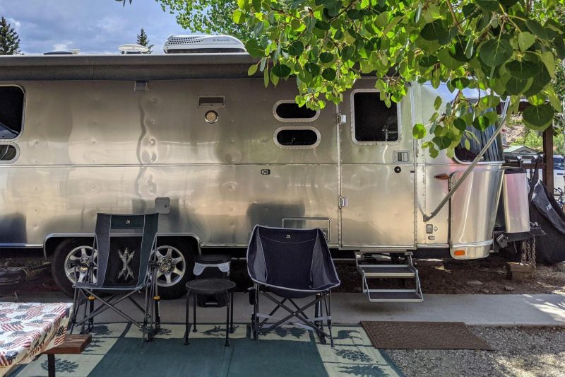 camp chairs next to an Airstream