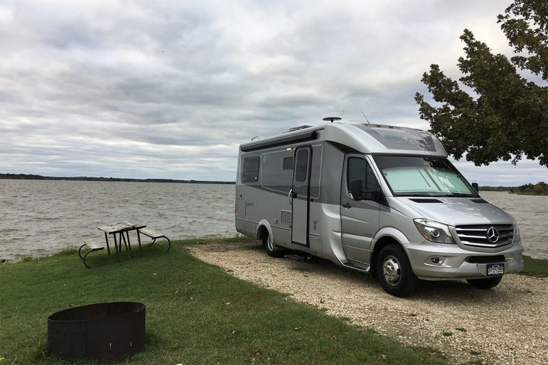 A van camping next to the water in a Kansas State Park