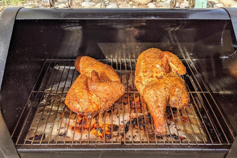 heavily seasoned chicken on smoker grill