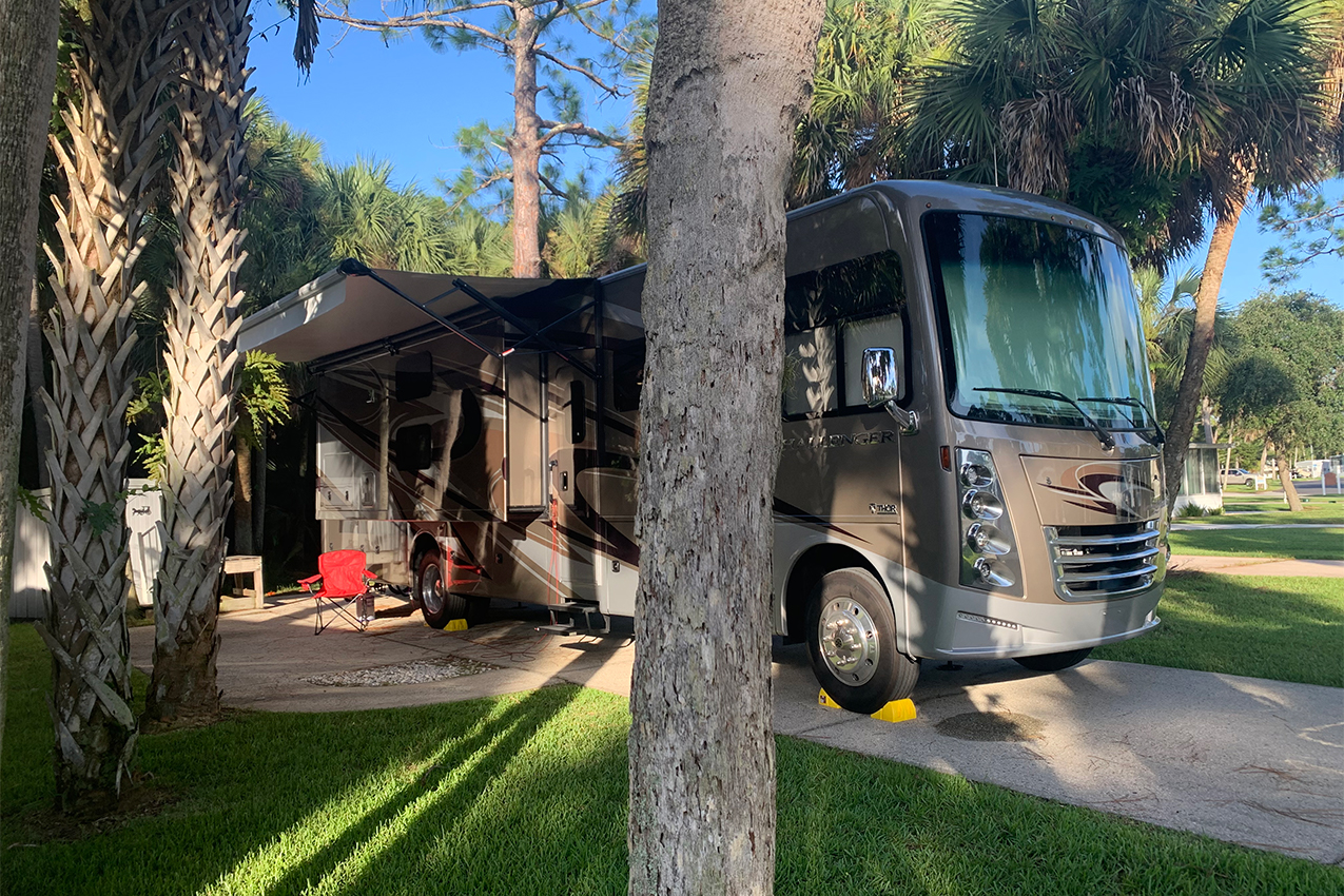 Class A parked in an RV spot surrounded by palm trees