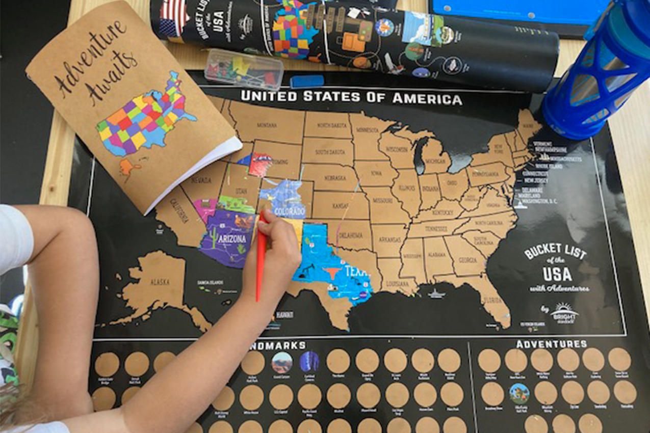 Child playing with a scratch off map