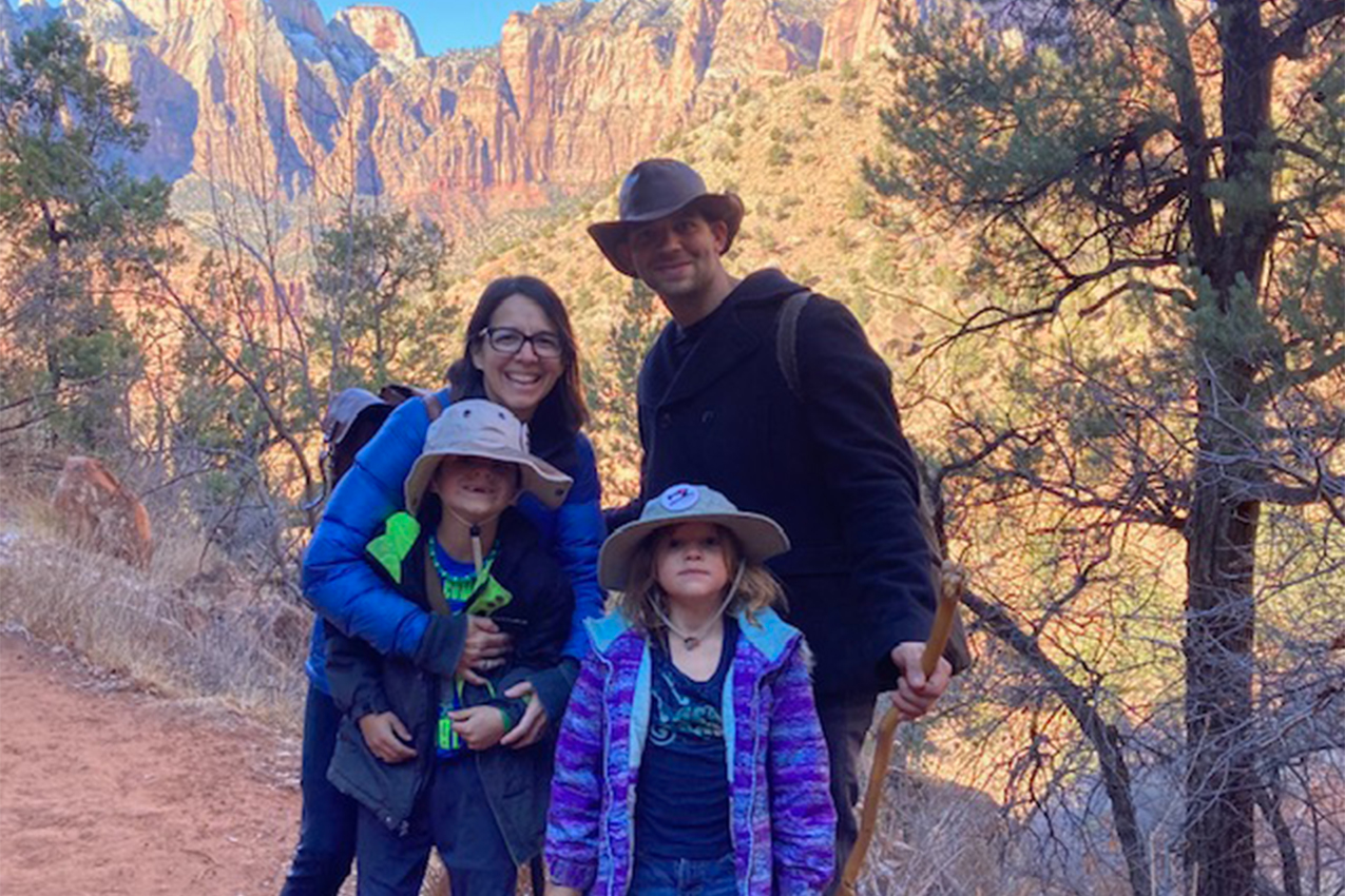 William, Carie and their kids standing in front of mountains.