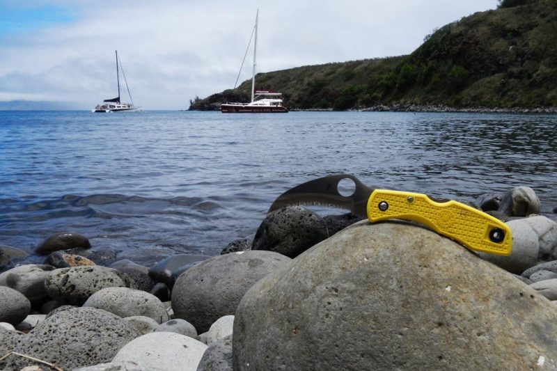 A knife on a rock with a sailboat in the background