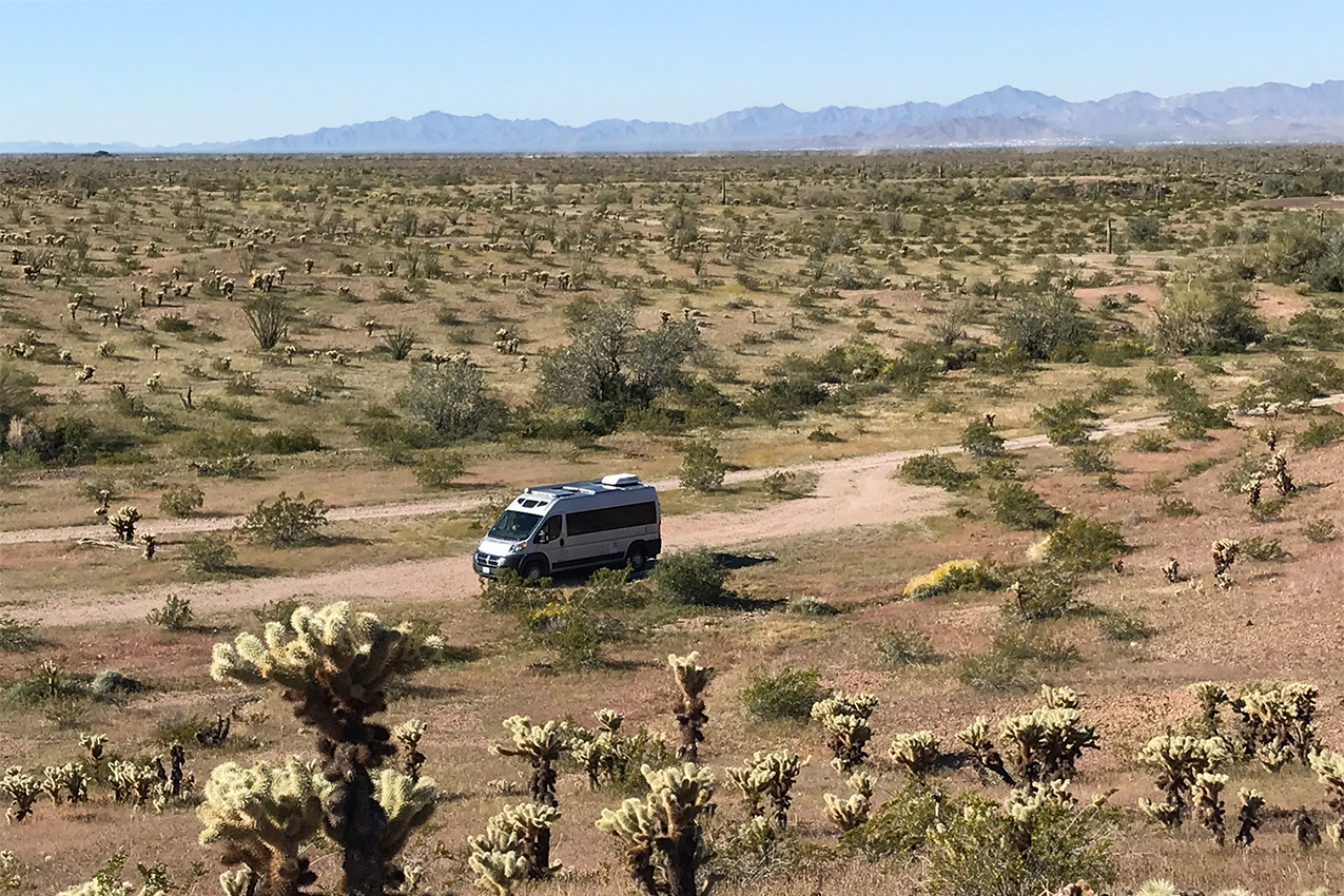 Van parked in a desert surrounded by cacti.