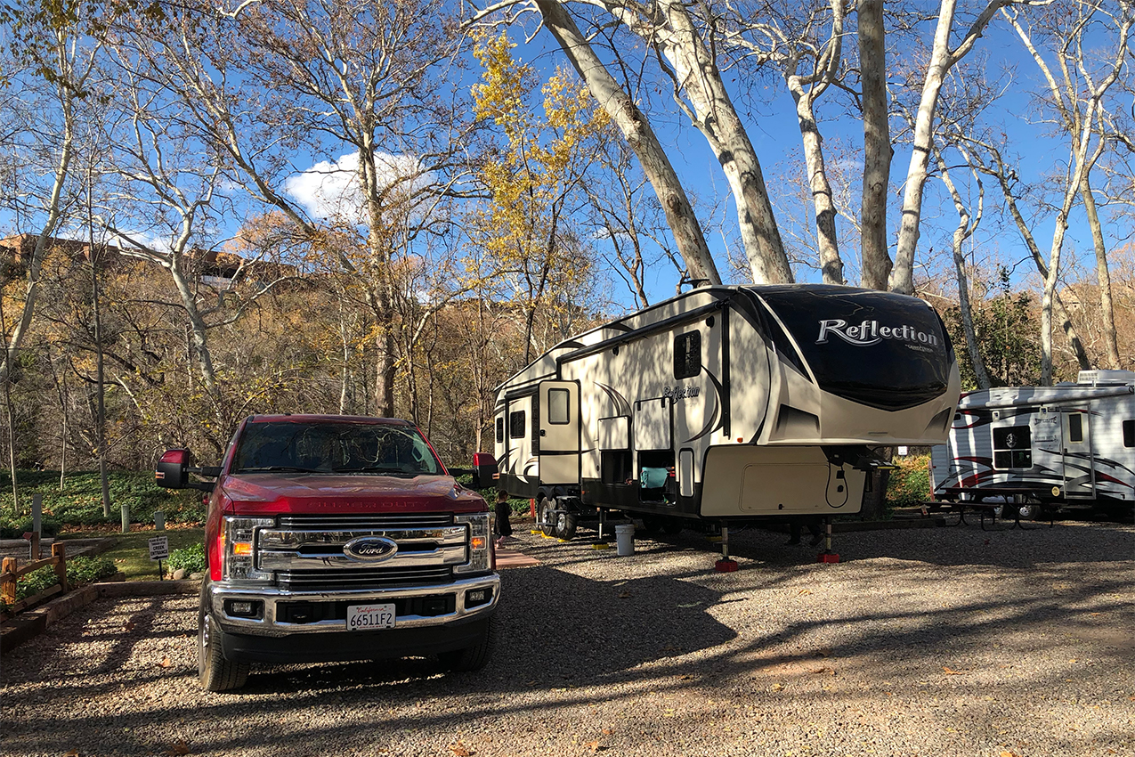 Truck and fifth-wheel parked in RV site.