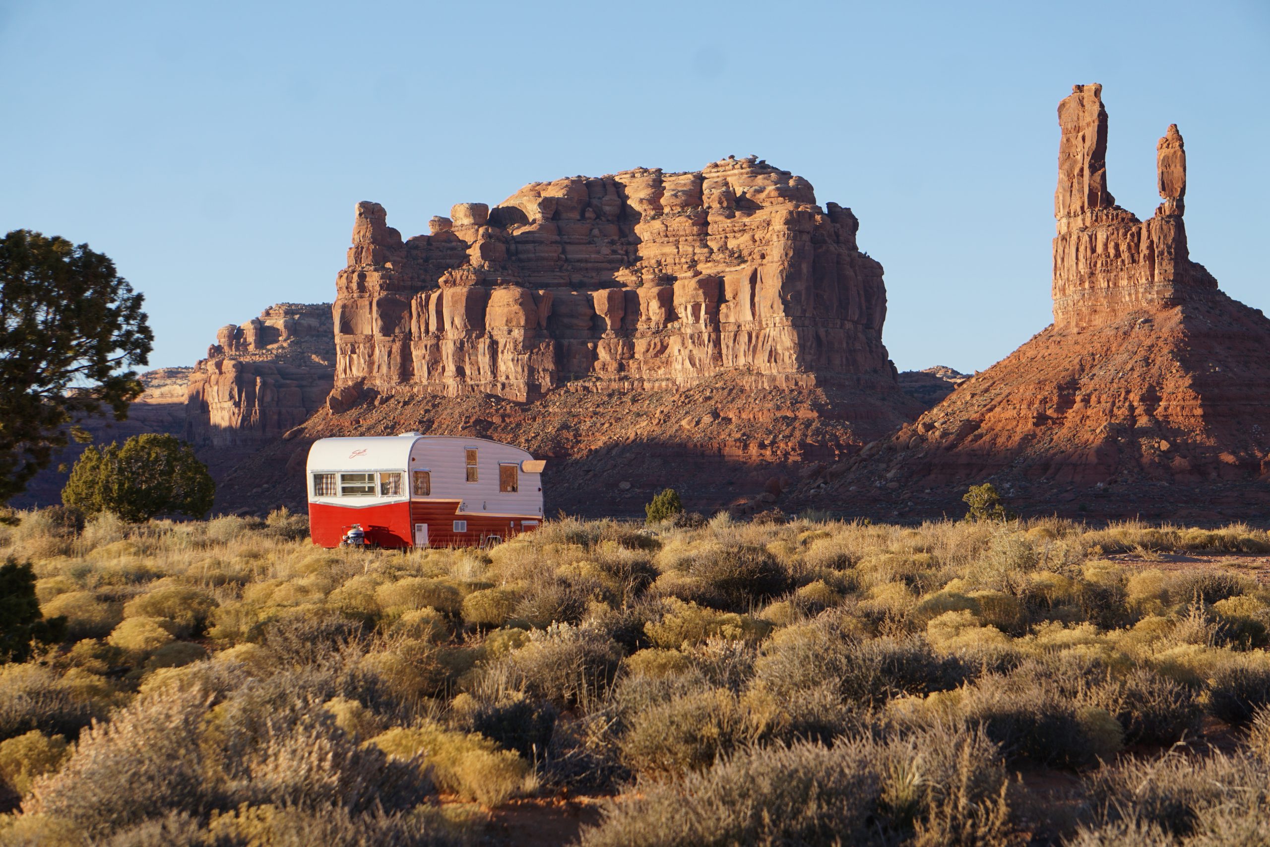 RV parked in front of red rock towers.