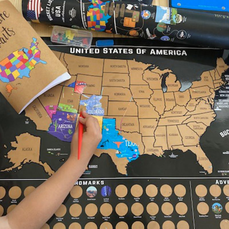 Child playing with scratch off map.