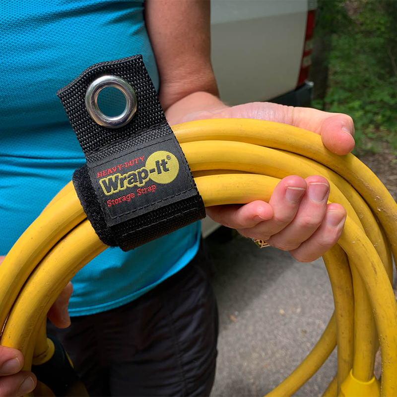 person holding an electrical cable held together with velcro straps