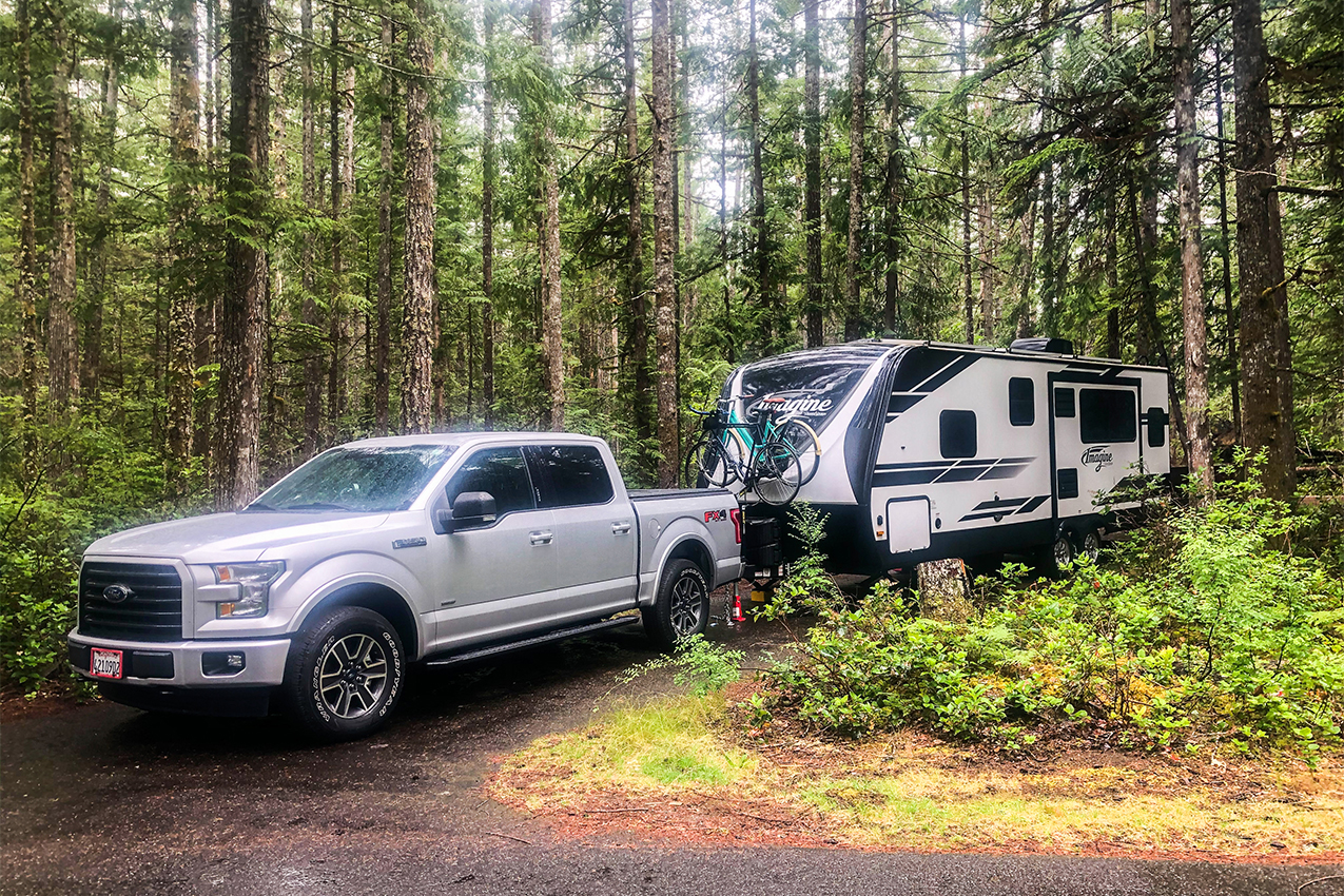 RV parked in the woods.