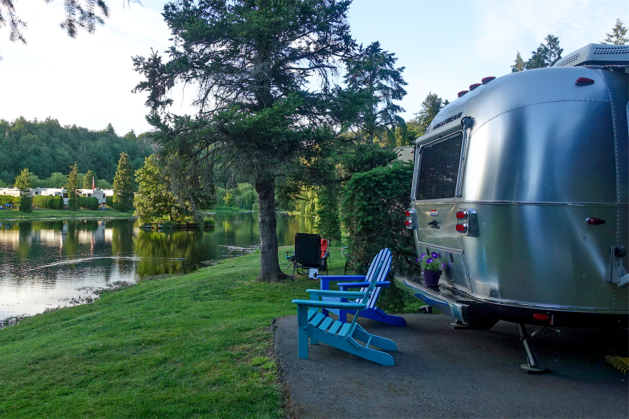 Airstream parked next to a lake.