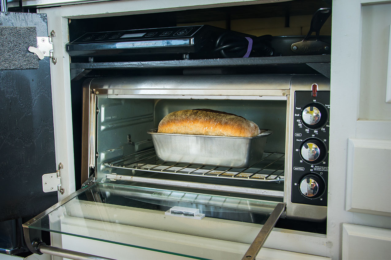 Toaster oven with a loaf of freshly baked bread in it.