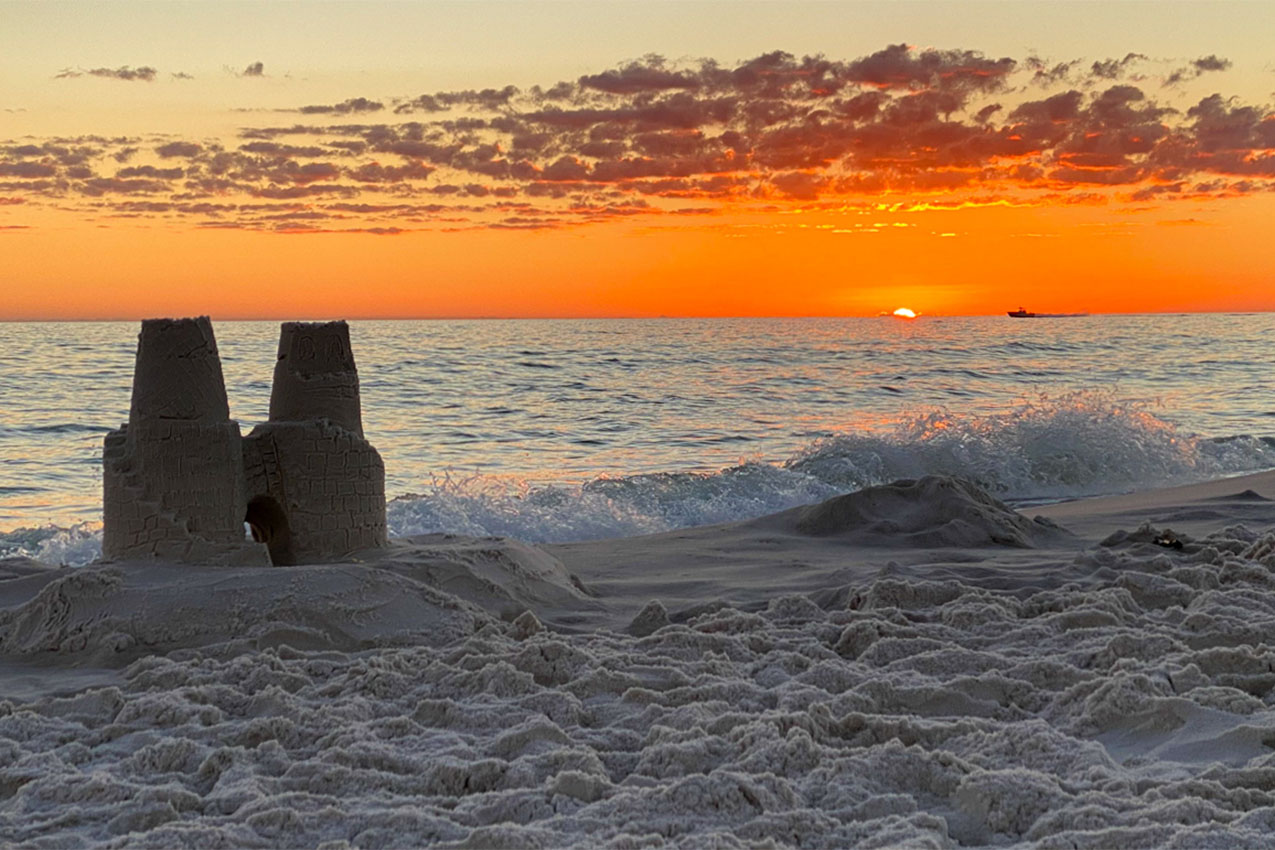 Sand castle on a beach at sunset.