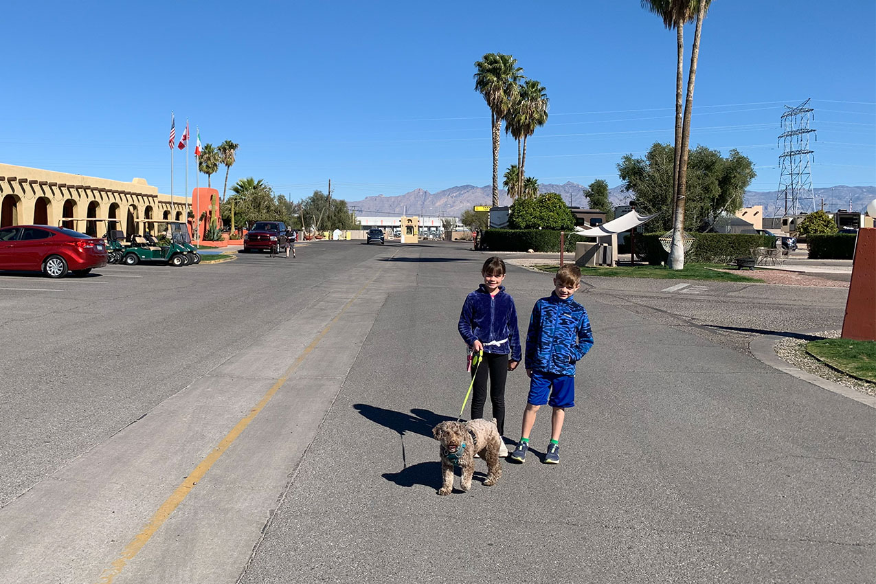 Two kids and their dog at an RV park.