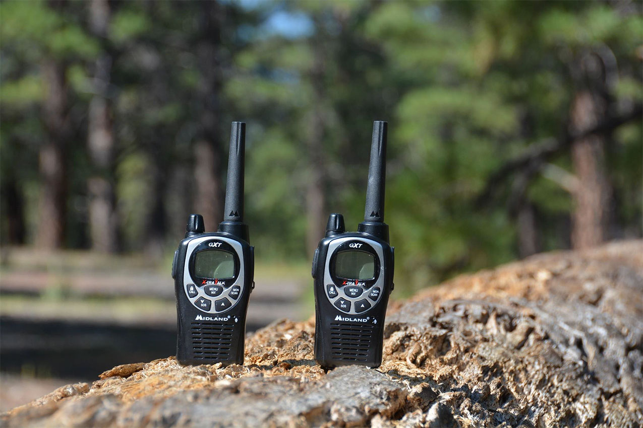 Two black walkie talkie on a rock.