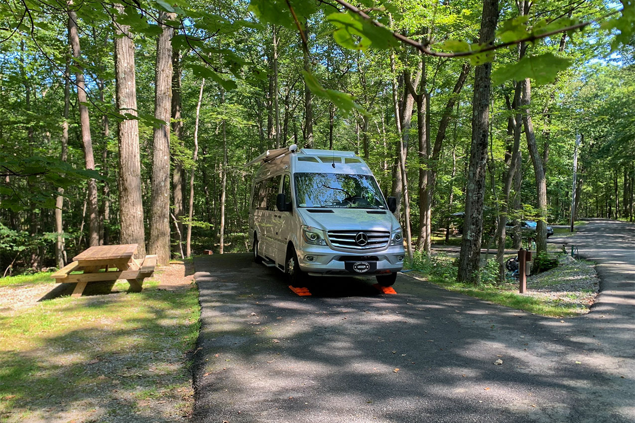 Van parked on blacktop in a county park.
