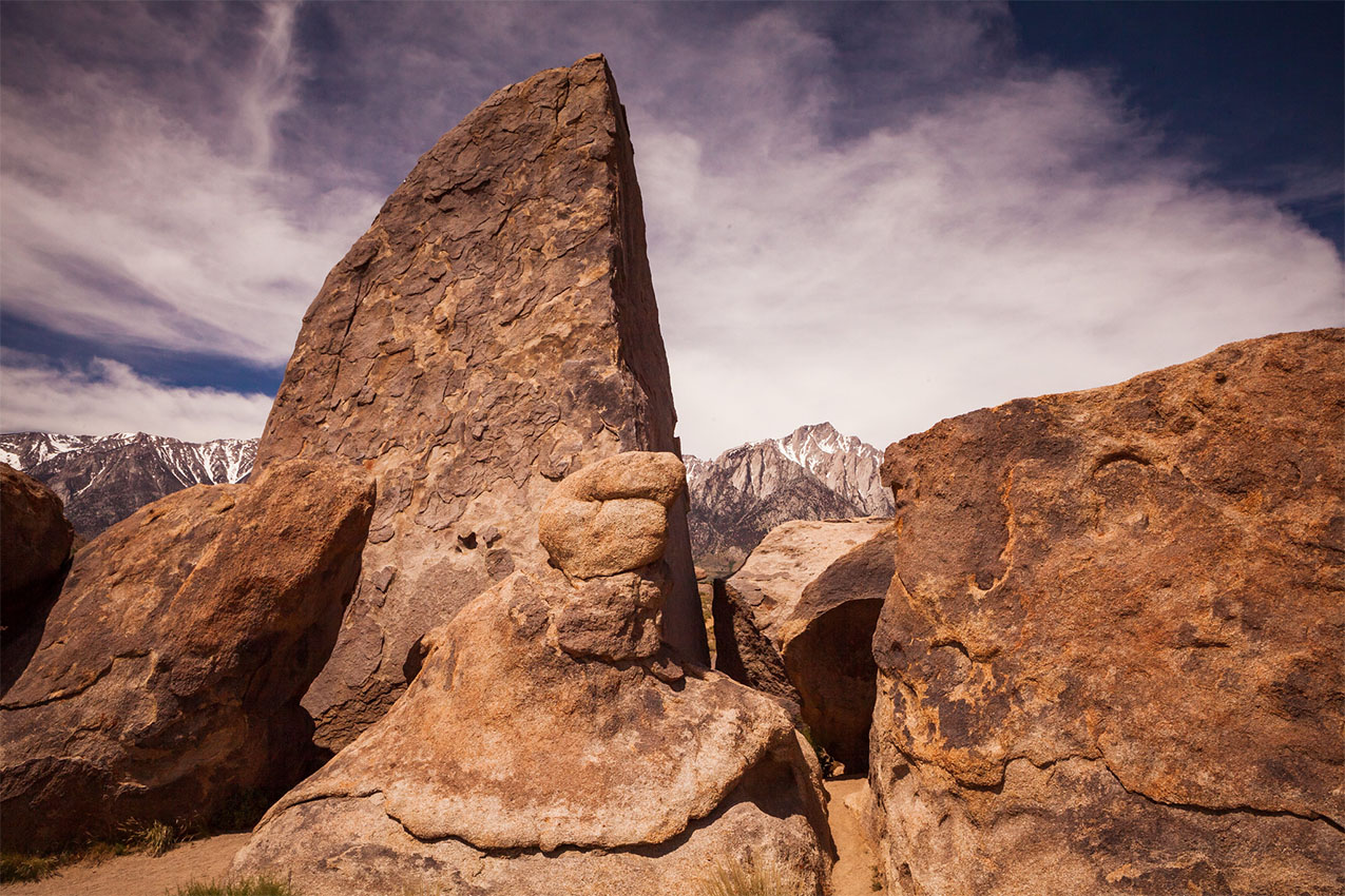 Large rock formation that resembles a shark fin standing above other rocks around it.