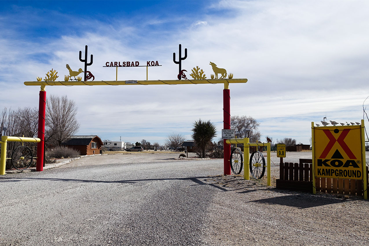 Entrance gate with on a gravel road for KOA campground.