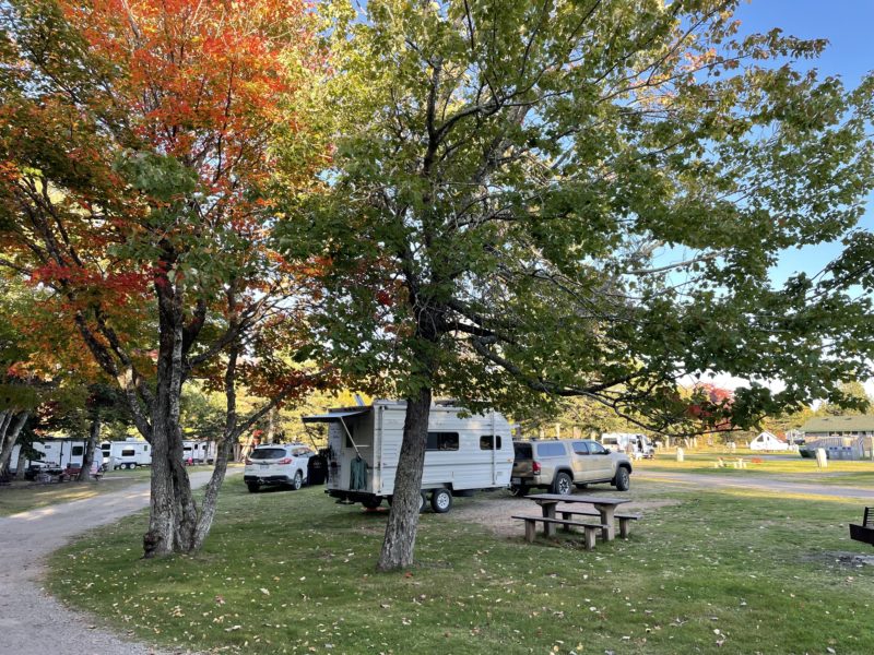 Trailer and truck at campsite with fall foliage