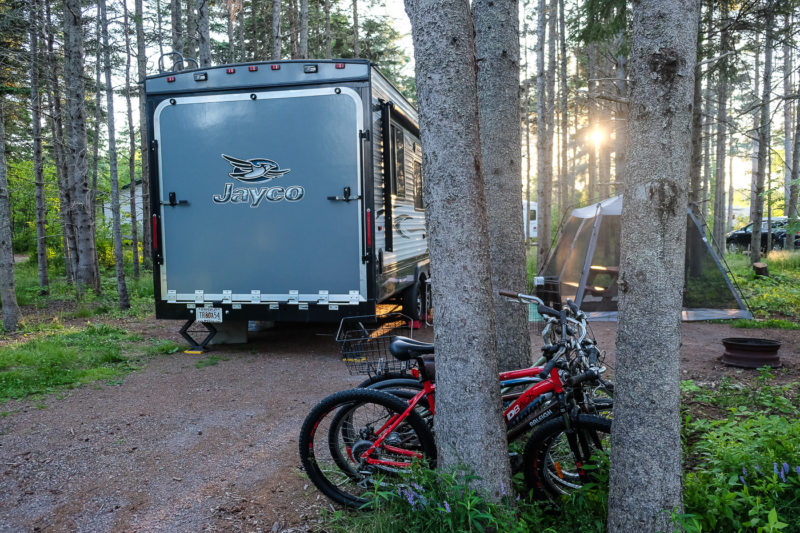 Trailer with tent and bikes at wooded campsite