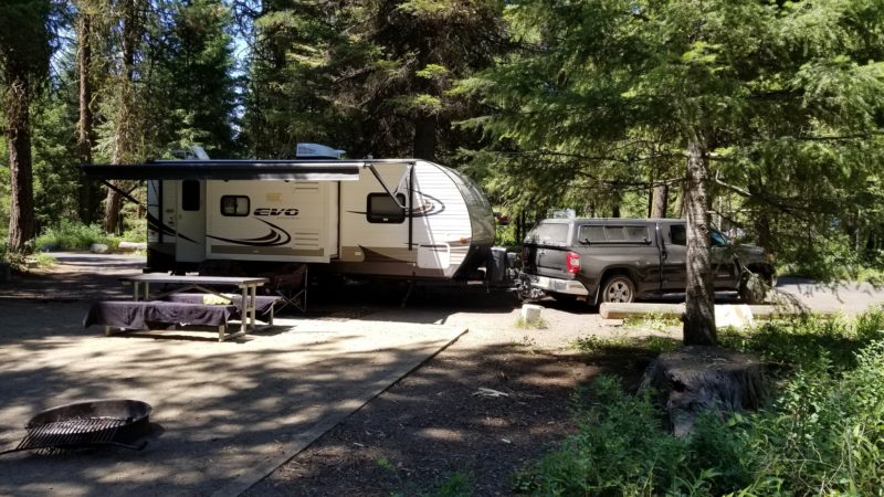 Truck and trailer with its awning out at a campsite