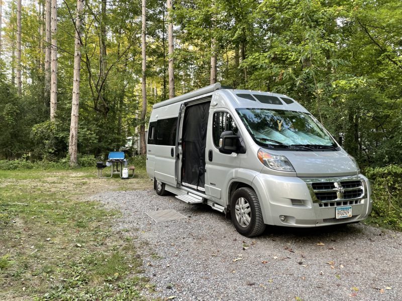 Class B parked in a wooded campground