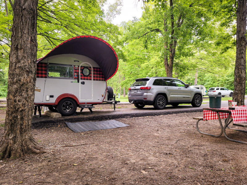 SUV and teardrop trailer parked at a campsite