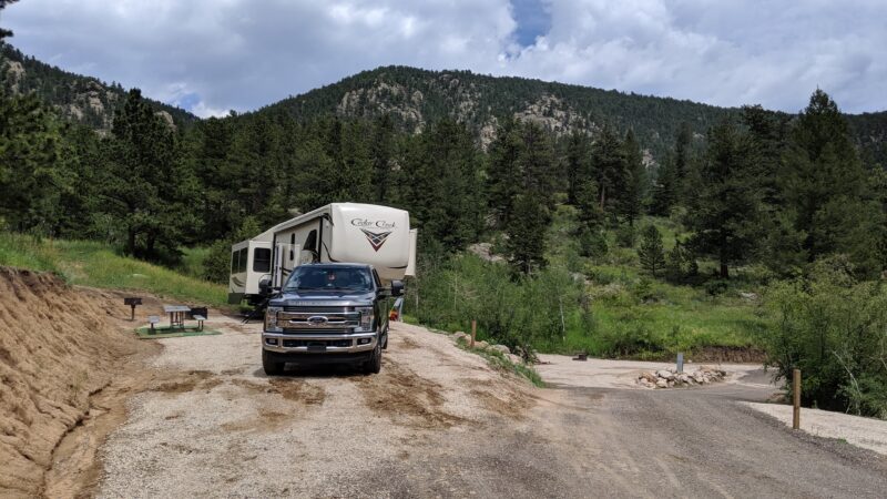 Fifth wheel RV parked at a campsite in the mountains near Estes Park, Colorado.