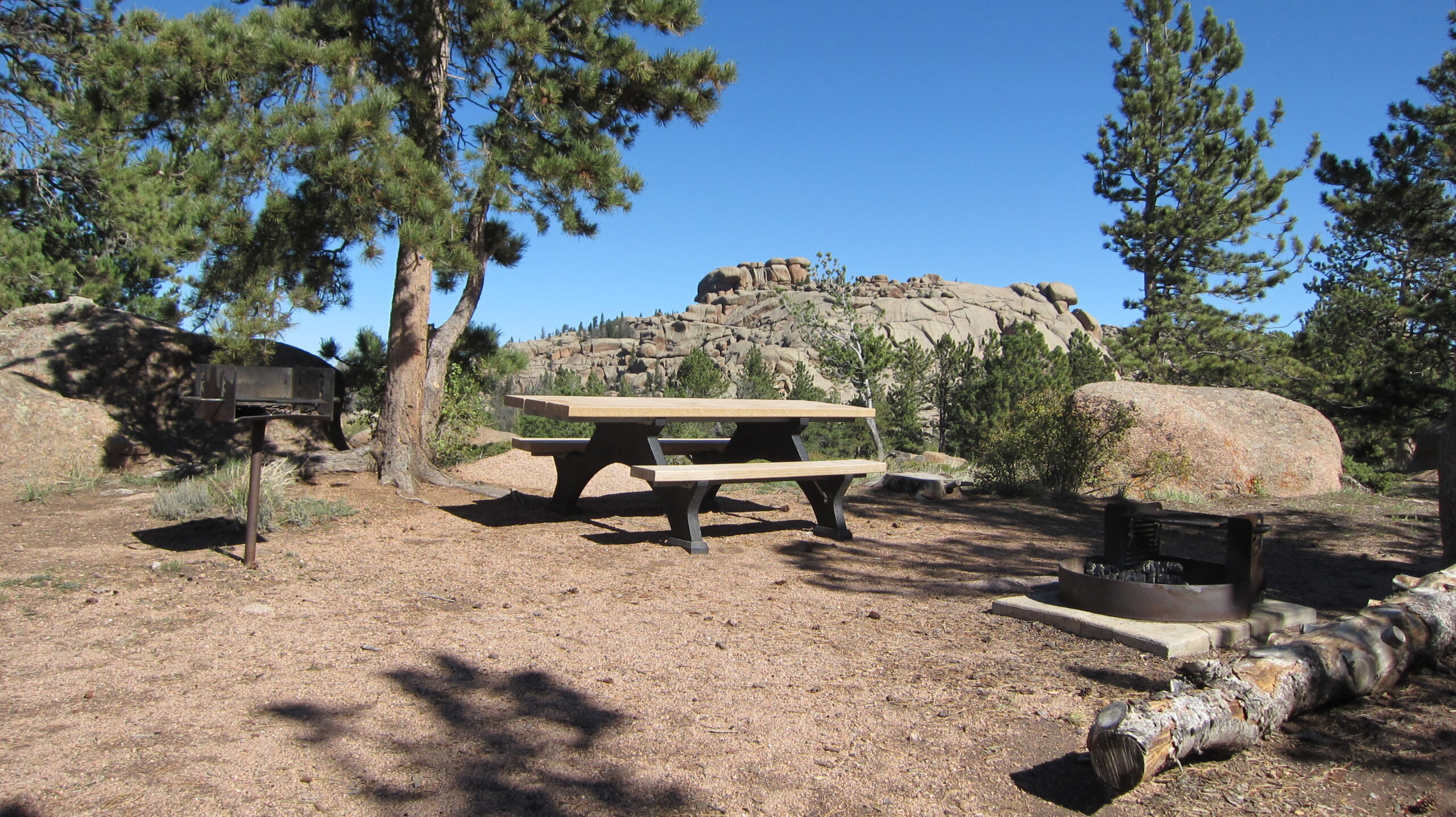 Picnic table at campsite with climbing rocks in background