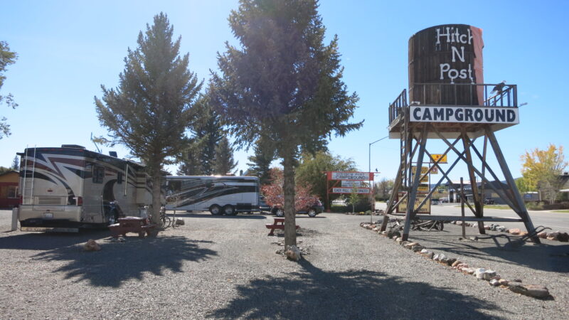 Water tower sign at campground with motorhomes parked at gravel sites