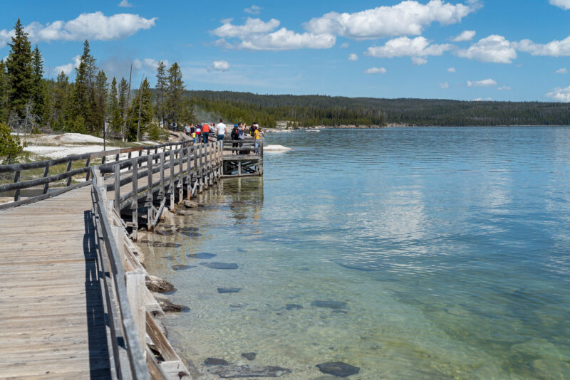 People walking on a wooden trail to see Yellowstone Lake
