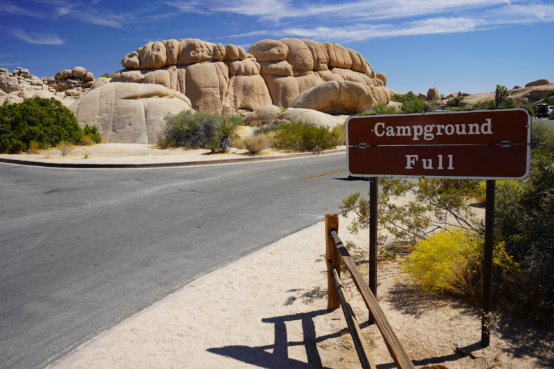 Boulder formations and a road with a sign that reads "Campground Full"