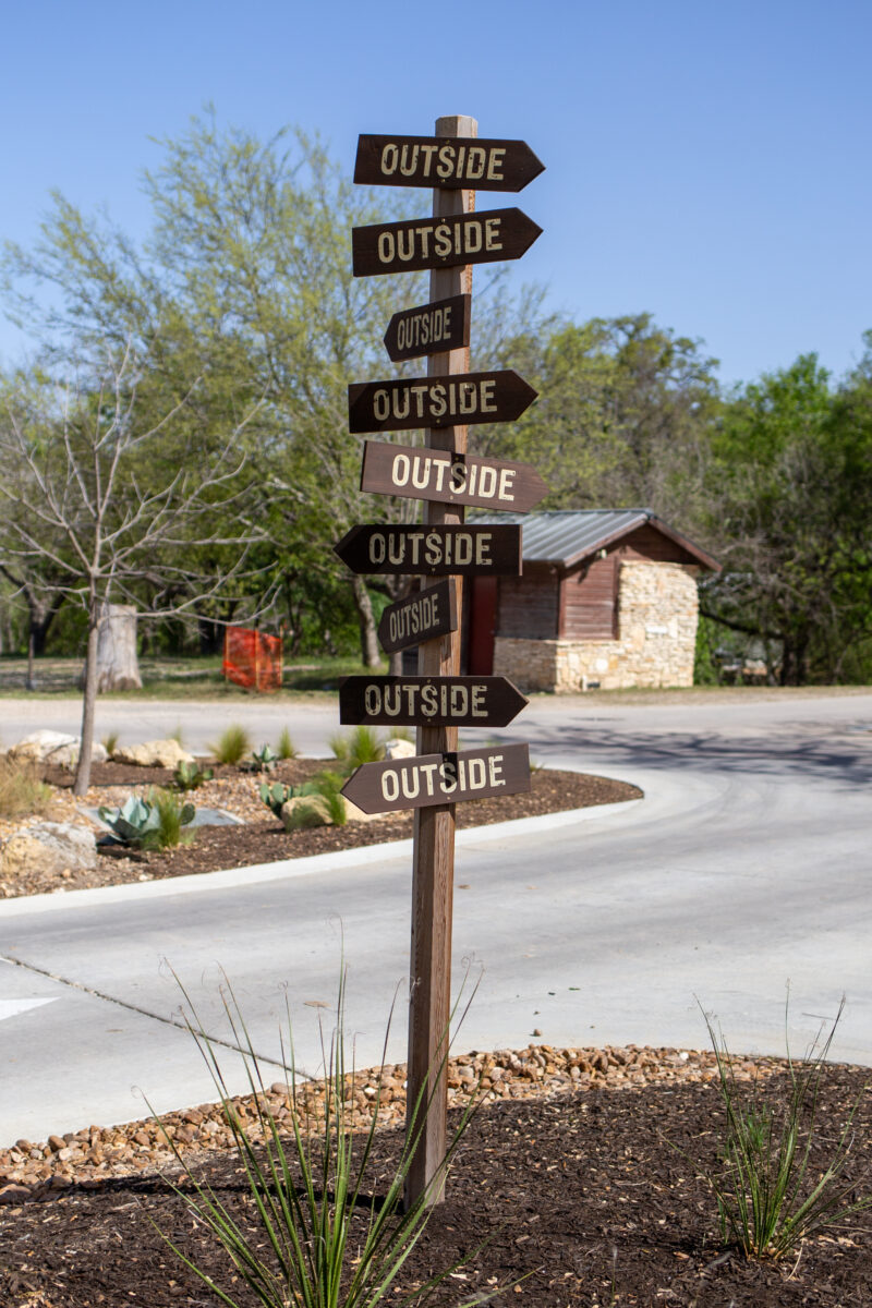 a wooden directional sign where every plank says "outside"