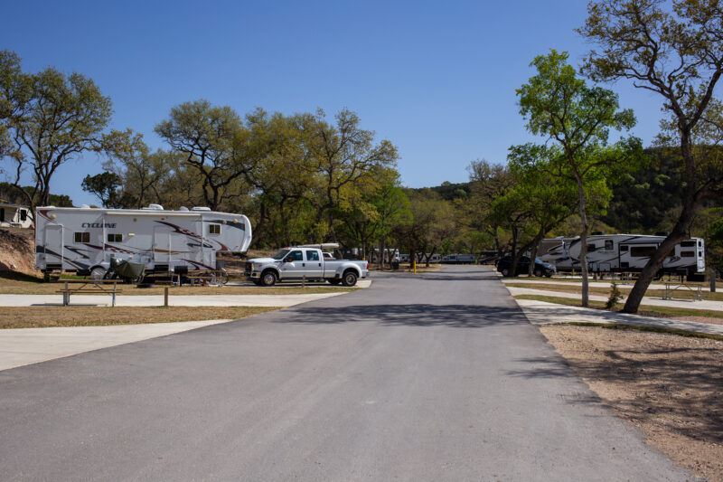 an rv park with cars and rvs set against a blue sky