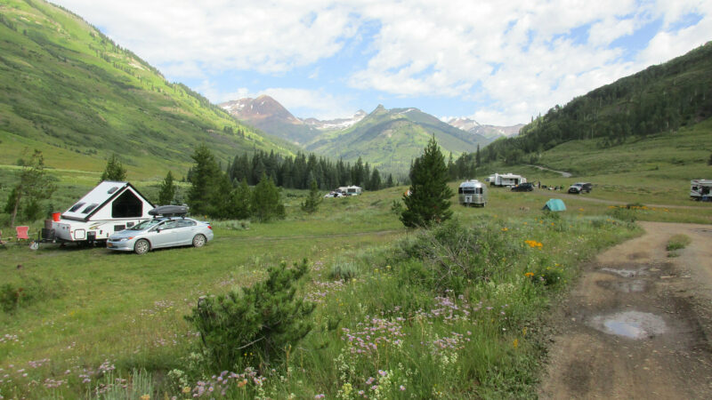 a green mountainous area with scattered rv campsites