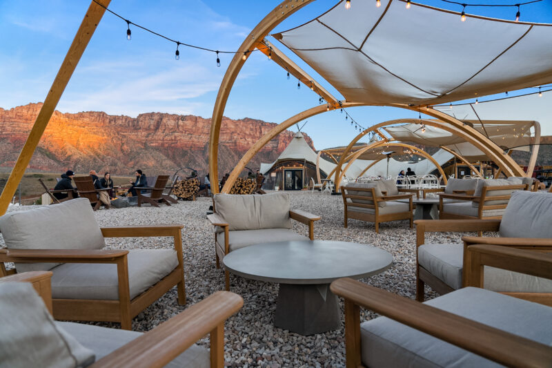 glamping tents with chairs and string lights in the desert