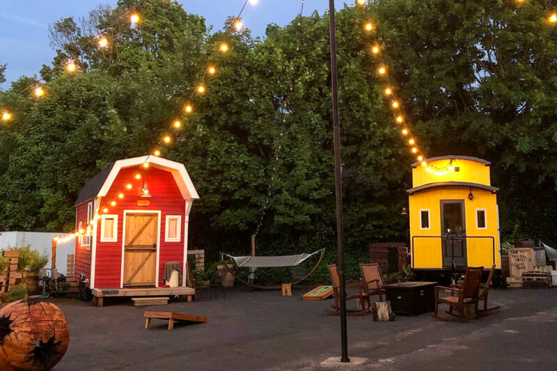 two tiny cabins outside with string lights