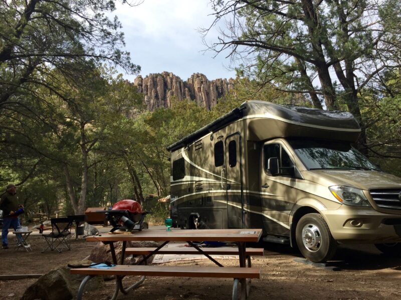 an rv at a campsite with a picnic table and scenic views