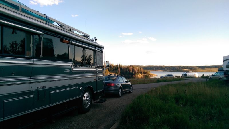 a car tows an rv next to the water