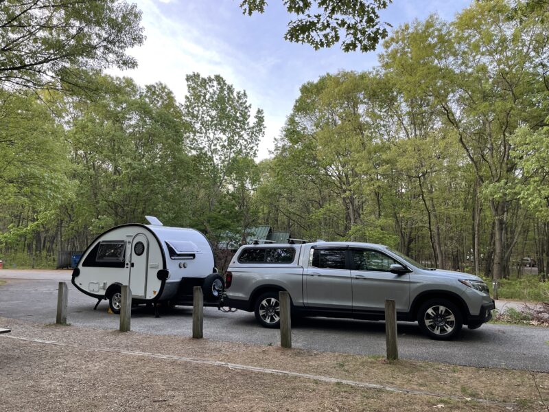 Teardrop trailer hitched to truck at campground