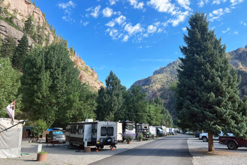 a campsite in the mountains with several rvs parked along a path