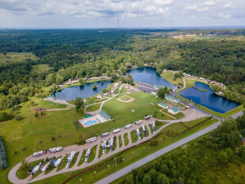 an aerial shot of a campground with water features and green trees