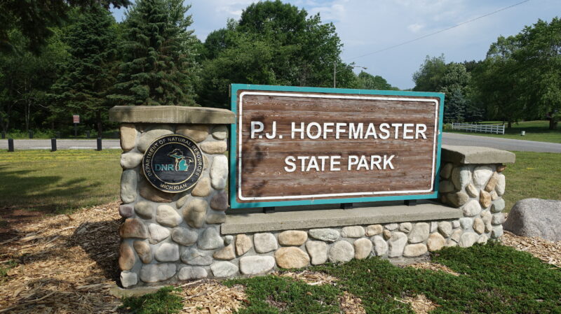 a stone and wood entrance sign for P.J. Hoffmaster state park