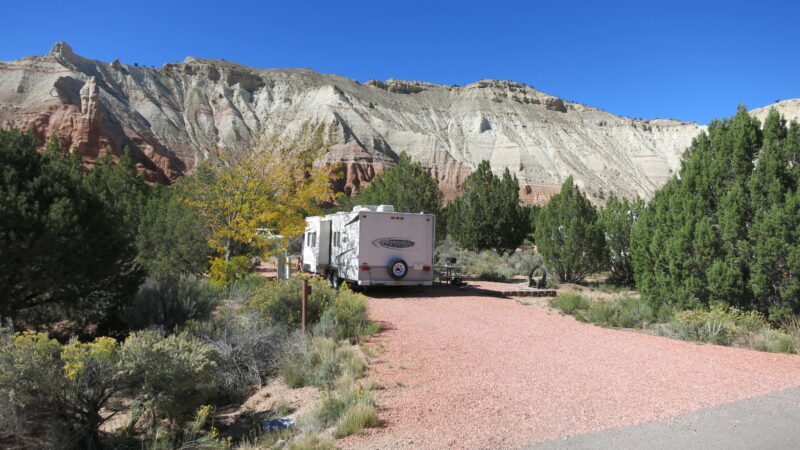 an rv is parked at a campsite in the desert with hills in the background