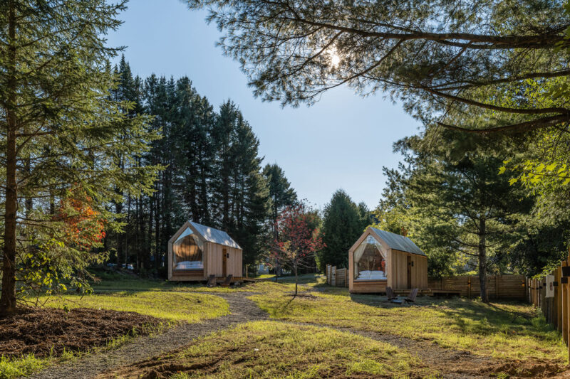 Upscale glamping cabins strike a modern feel in a well-kept tree-lined camping locale.
